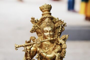 Detailed close-up of a golden Hindu deity figurine showcasing intricate artistry and religious significance.